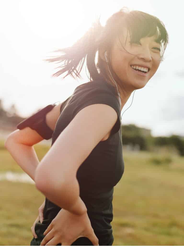female runner laughing on field in morning picture id596086200