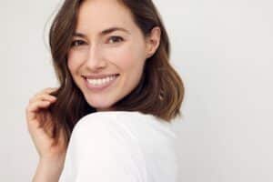 Woman smiling with raised brows from endoscopic brow lift in Dallas, TX