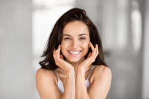 Woman smiling with fresh, glowing skin from a HydraFacial in Dallas, TX